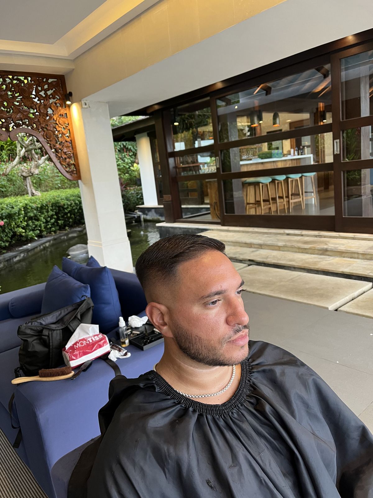 Client in a cape in an open-air lobby